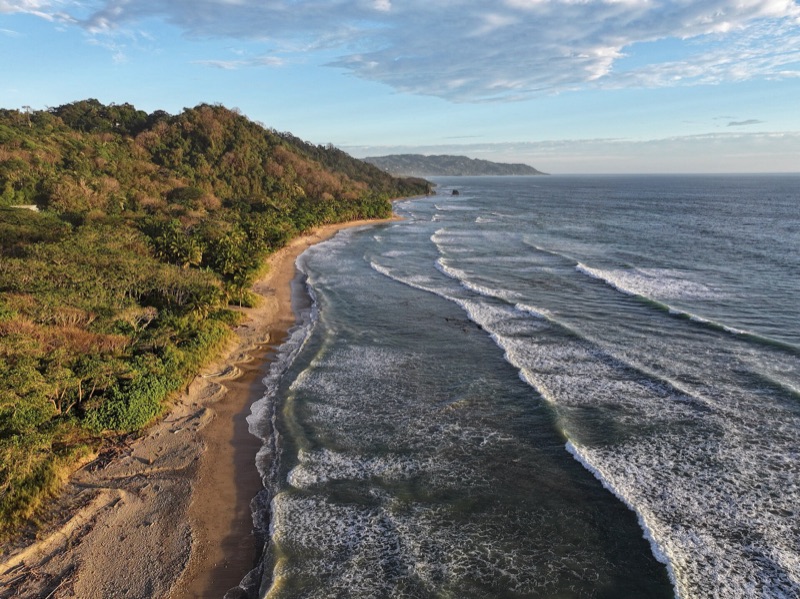 Aerial view of forested coast and surf near Playa San Miguel in Cabo Blanco Nature Reserve