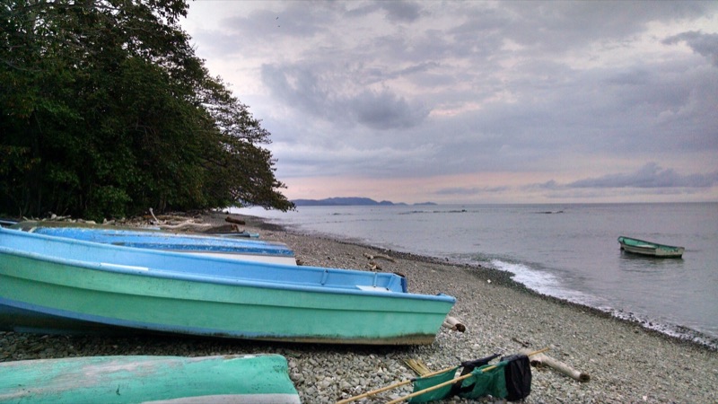 Turquoise fishing boats pulled up on the shore at Cabuya