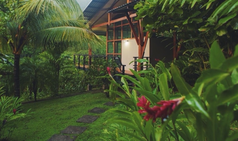 A cabin at The Sanctuary at Two Rivers among palms and tropical gardens